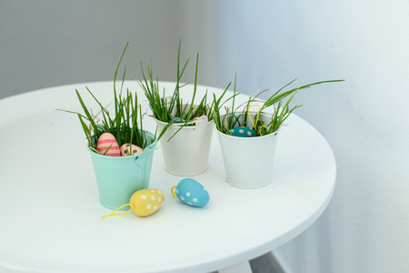 A selective focus shot of decorative colorful eggs in small buckets with grass - Easter concept