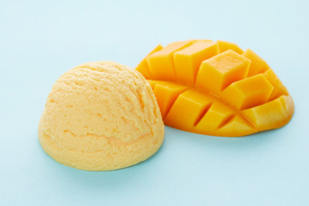 A selective focus shot of delicious ice cream scoop with mango isolated on a blue background