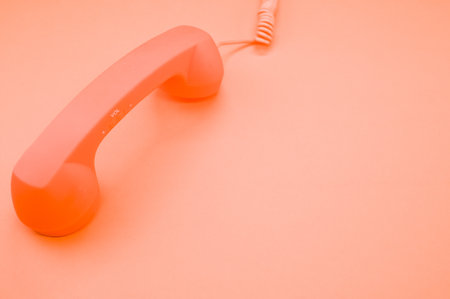A classic handset on pastel orange background for a copy spaceの写真素材