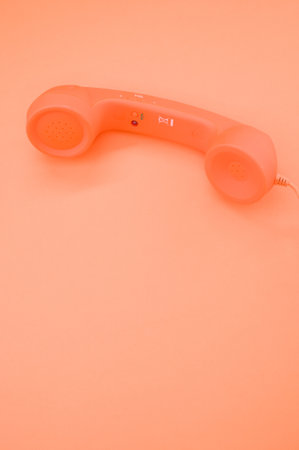 A vertical shot of a classic handset on pastel orange background for a copy spaceの写真素材