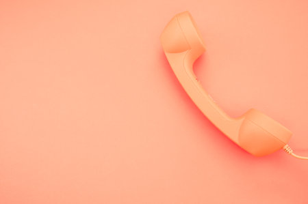 A classic handset on pastel orange background for a copy spaceの写真素材