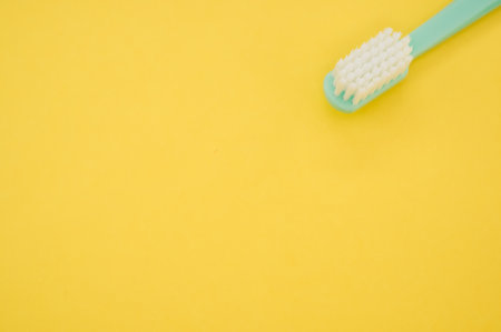 A turquoise toothbrush on a yellow surface for a copy spaceの写真素材