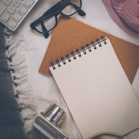 A top view closeup of the notebook, planner, eyeglasses, and camera on the bed- concept planning a travelの写真素材