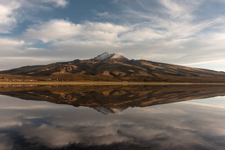 A mountain with snow on its top reflected on the lake