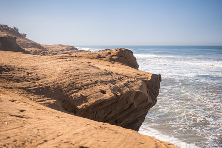A scenic view of the rocky cliff by the coast on a clear sky background