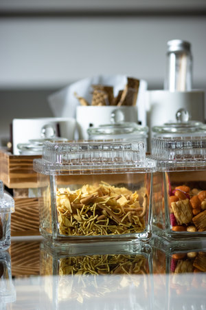 Different salted and sweet cookies in transparent glass boxes on a kitchen tableの写真素材