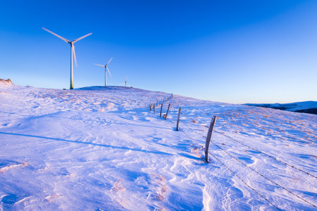 Windmill plant park on a mountain ridge in Austria on a cold winter day.