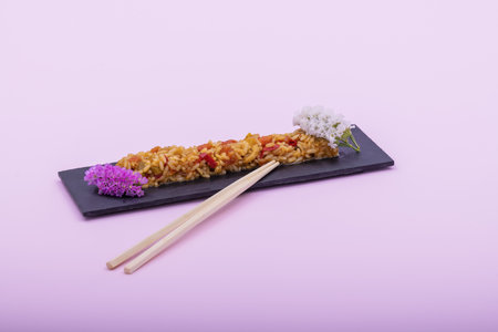 A plate of fried rice decorated with flowers on a pink backgroundの写真素材