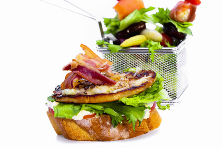 A closeup shot of a delicious sandwich and with vegetable salad isolated on white backgroundの写真素材