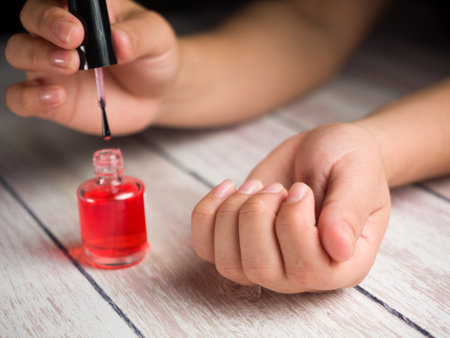 A woman applying a red treatment oil for nailsの写真素材