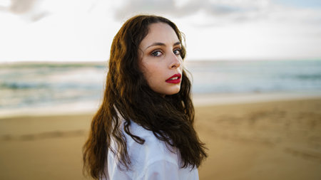 A portrait of a beautiful girl with red lipstick at the beachの写真素材