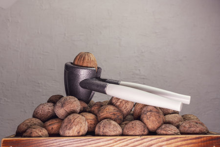 A closeup shot of walnuts with a nutcracker in a wooden boxの写真素材