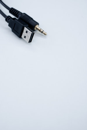 A vertical shot of a wire with a USB end and audio cable on a blue backgroundの写真素材