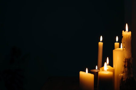 A closeup shot of burning candles in a dark room
