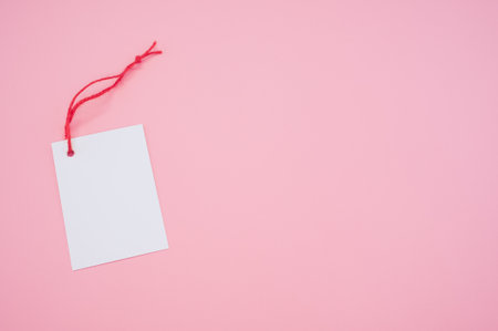 A blank tag with a red string on a pink backgroundの写真素材