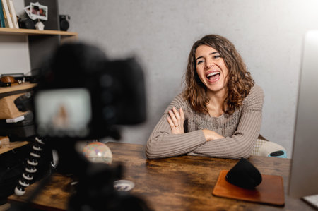 A young cheerful Caucasian female social media influencer filming a casual video blog with positive vibesの写真素材