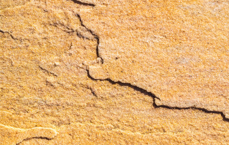 A closeup shot of a damaged yellow stone wall - Perfect for backgroundの写真素材