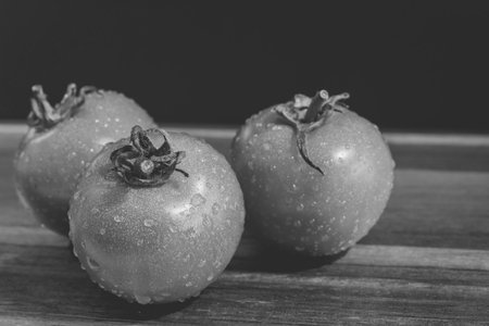 A grayscale closeup shot of freshly washed wet tomatoesの写真素材