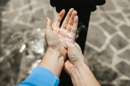 An overhead shot of soapy female hands, correct washing hands method during coronavirus pandemicの写真素材