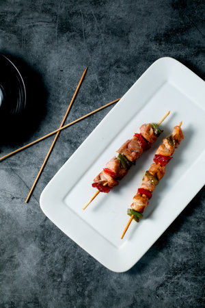 A vertical closeup of grilled meat and vegetables on skewersの写真素材