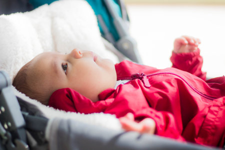 A shallow focus of a newborn child lying in a baby carriage under the sunlightの写真素材