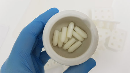 A closeup shot of a scientist's or researcher's hand holding suppositories in the pharmacy...