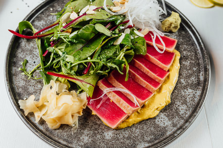 A closeup of a plate of sushi with fresh vegetables on the white tableの写真素材