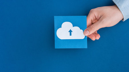 A male hand holding delivery truck shape symbol on blue backgroundの写真素材