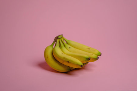 A closeup shot of fresh bananas isolated on pink baの写真素材