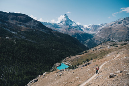 Several unrecognizable hikers walking by the path towards the Matterhorn peak in Zermatt, Switzerlandの写真素材