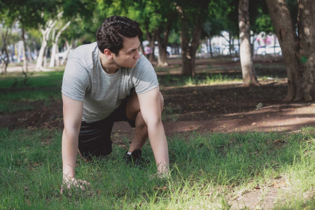 A shallow focus of a young male exercising in a park under the sunlight