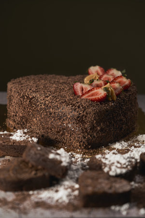 A vertical shot of a delicious creamy heart-shaped chocolate cake with strawberries