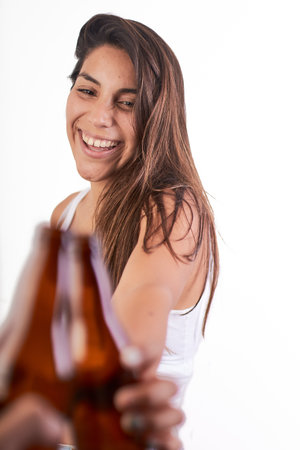 A young pretty female toasting with a beer bottleの写真素材