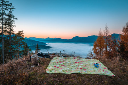 A romantic picnic with sunset over Carpathian Mountains covered with fog in Europe, Slovakiaの写真素材