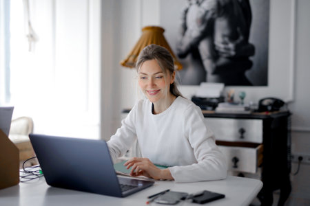 A young successfull female working on a laptop at homeの写真素材