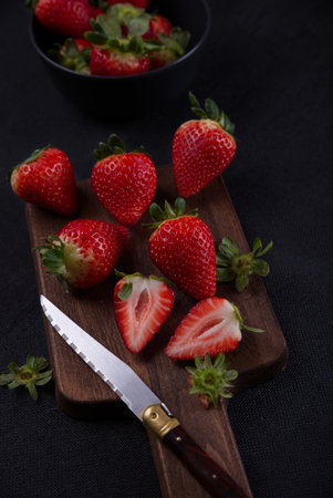 Fresh strawberries on black background, laid out on top of a wood.の写真素材