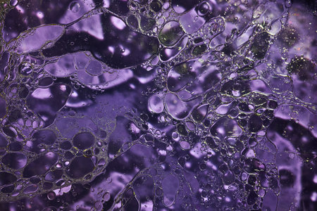 A closeup shot of a purple water surface with bubblesの写真素材