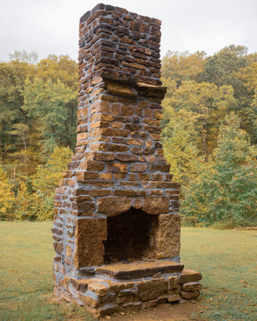 A vertical shot of a brick chimney  the forest in autumnの写真素材