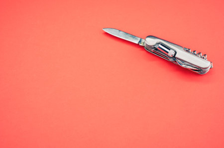 An isolated shot of the multifunctional pocket knives on a pink backgroundの写真素材