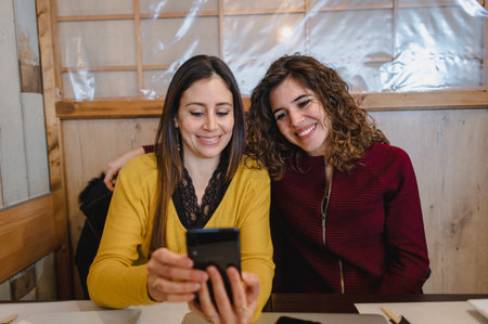 A smiling Hispanic women having a video call over a phoneの写真素材