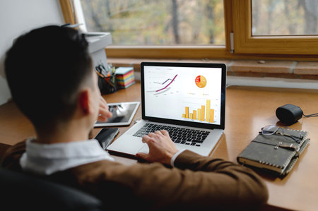 A young businessman working on his new business project using laptop to see the graphs at this workplaceの写真素材