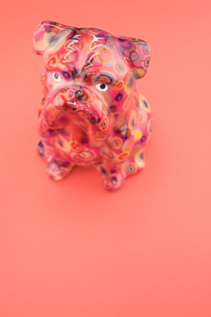 A vertical isolated shot of the puppy figurine on a pink backgroundの写真素材