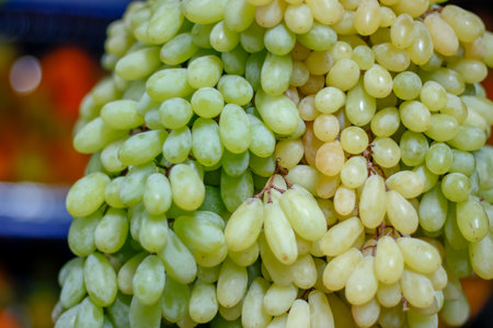 A close-up shot of green ripe grapes on a blurry background in the marketの写真素材
