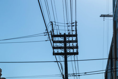 A low angle shot of the  overhead wires with clear blue sky behindの写真素材