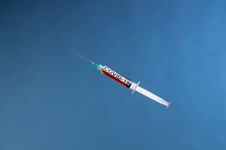 A syringe for Covid-19 vaccination a blue backgroundの写真素材