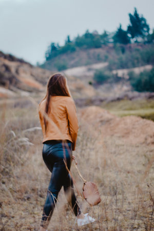 A vertical shot of a lady walking in the Sabrinsky desert in Bogota, Colombiaの写真素材