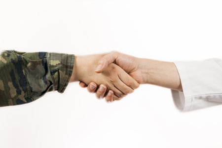 A closeup of a handshake of a soldier and a doctorの写真素材