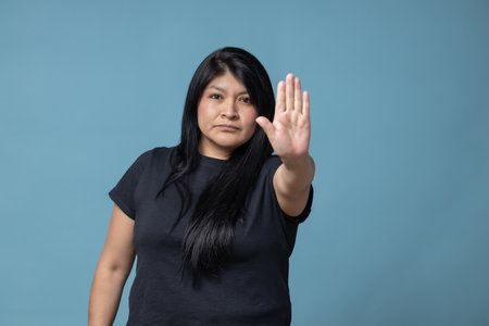 A Latin female showing the stop sign with her handの写真素材