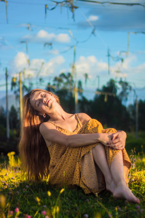A a young woman in a beautiful dress  in a flowered parkの写真素材
