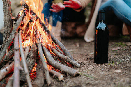 A shallow focus of people gathered around a fire outdoorsの写真素材